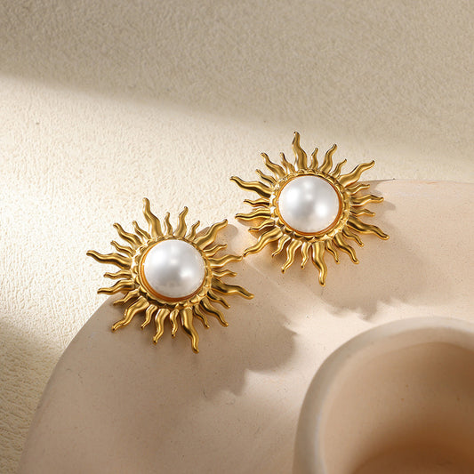 Paired vintage-style gold sunburst stud earrings featuring a central lustrous white pearl