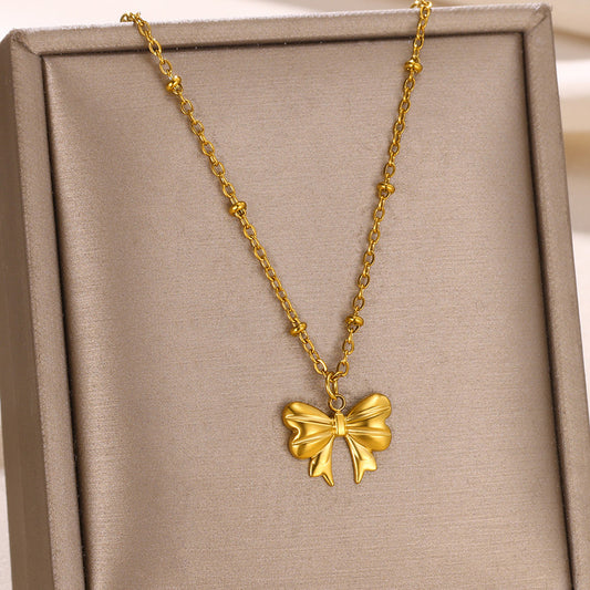Minimalist gold bow pendant necklace featuring a polished three-dimensional bow on a dainty beaded chain for everyday elegance