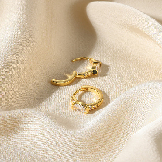 Elegant paired gold huggie hoop earrings with continuous clear zirconia and a central marquise-cut stone