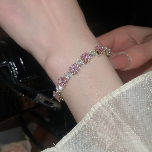 Sparkling gold tennis bracelet featuring multi-color and pink cubic zirconia in a continuous link design
