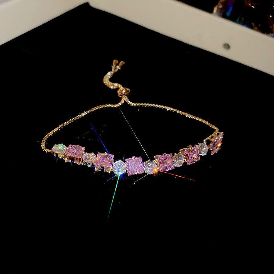 Sparkling gold tennis bracelet featuring multi-color and pink cubic zirconia in a continuous link design