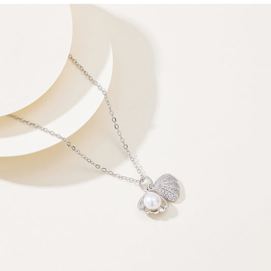 Elegant gold silver necklace featuring a shell-shaped pendant with a central pearl and shimmering zircon stones on the outer rim