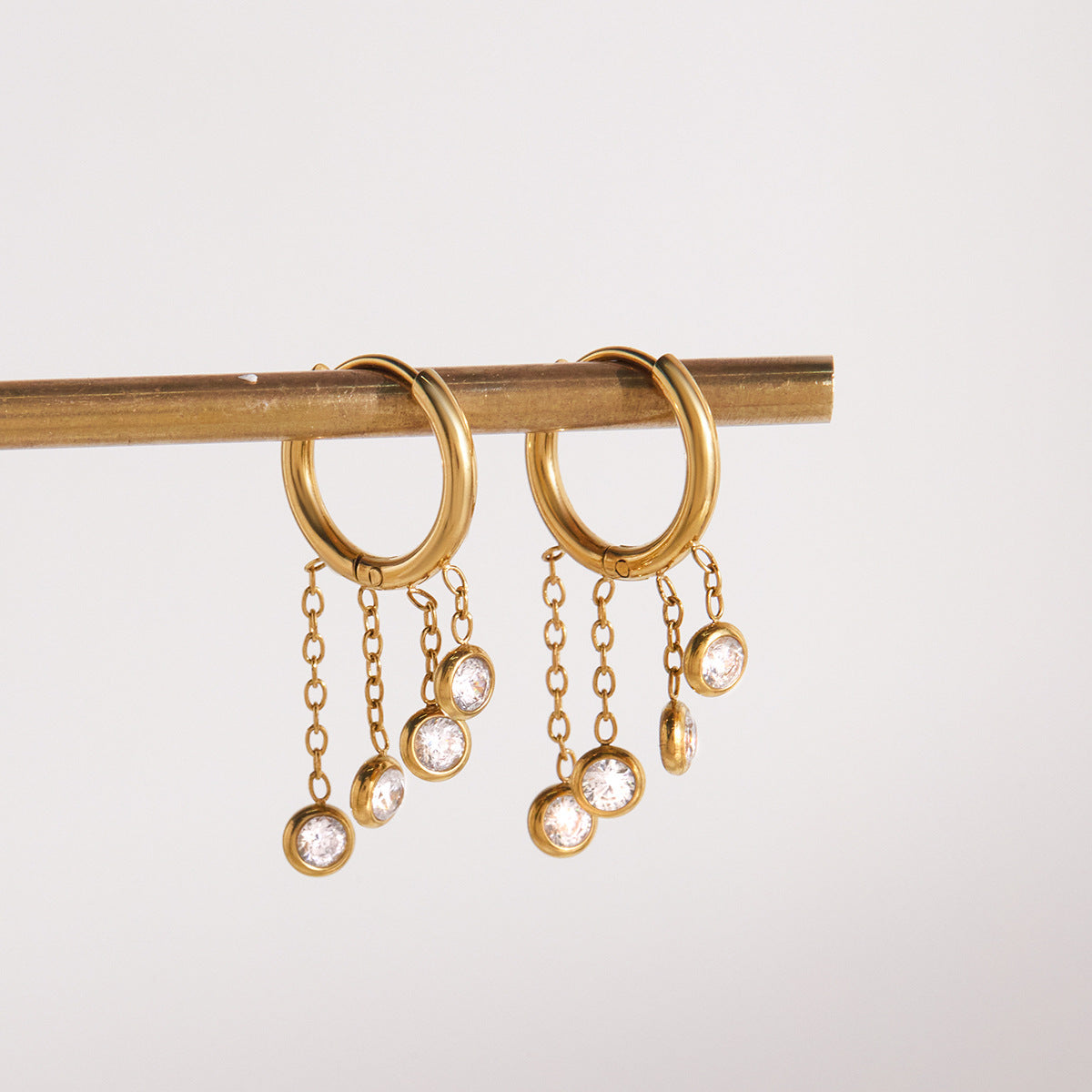 Gold stainless steel chunky hoop earrings featuring three rows of sparkling clear zirconia stones