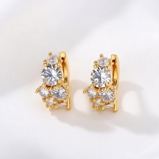 Gold huggie hoop earrings featuring a continuous row of sparkling clear zirconia stones in a polished pave