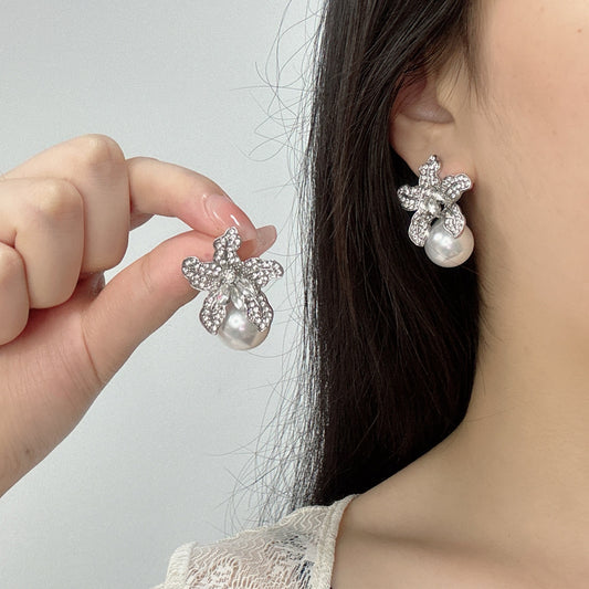 Elegant S925 sterling silver lily flower stud earrings featuring a lustrous white pearl center in a silver tone
