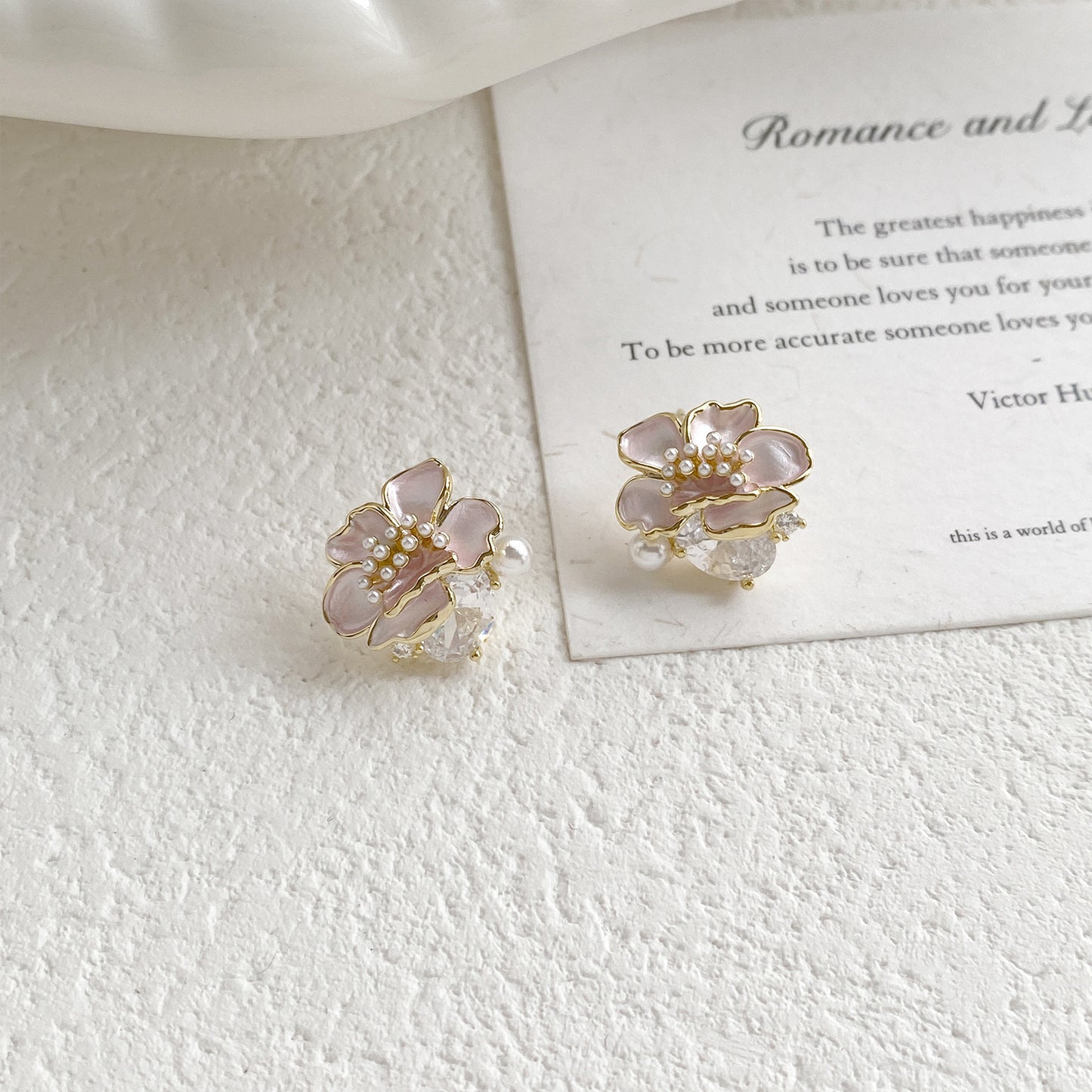 Pink floral stud earrings in S925 silver with a sparkling zirconia center and a dangling white pearl charm