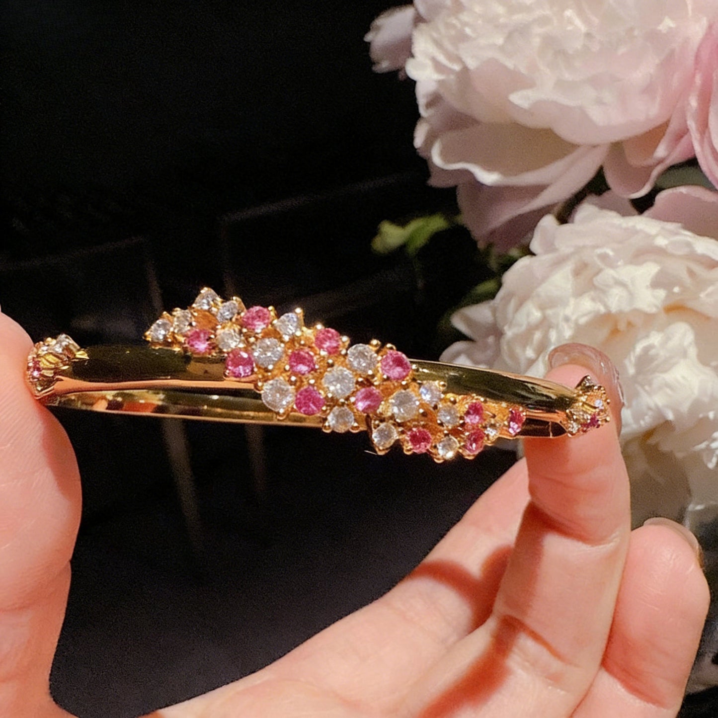 Exquisite 18K gold plated bangle featuring a pink gemstone center, floral motifs, and sparkling zirconia accents