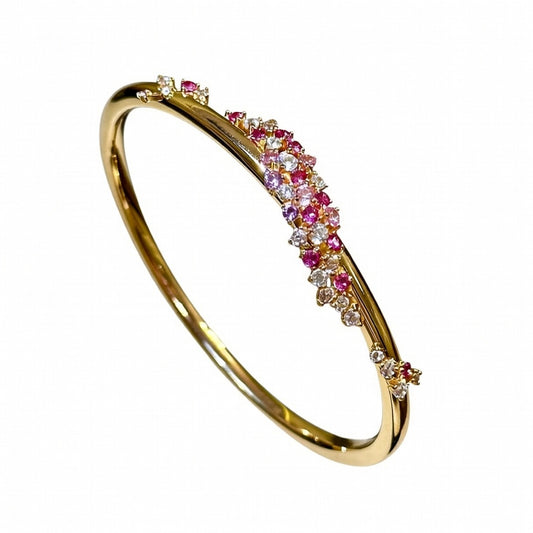 Exquisite 18K gold plated bangle featuring a pink gemstone center, floral motifs, and sparkling zirconia accents