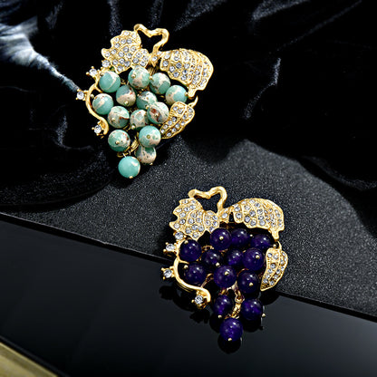 Elegant 18K gold plated grape brooch featuring mint green and purple cubic zirconia stones in a fruit-themed design