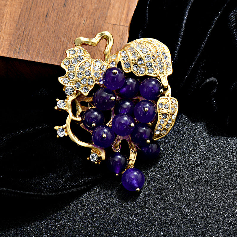 Elegant 18K gold plated grape brooch featuring mint green and purple cubic zirconia stones in a fruit-themed design