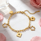 Floral openwork charms engraved lucky tag and geometric drop link chain stainless steel jewelry bracelet in waterproof 18k gold plated finish.