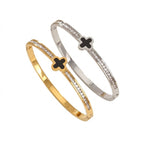 Black enamel clover station and channel-set cubic zirconia hinged cuff bangle in waterproof 18k gold plated stainless steel jewelry.
