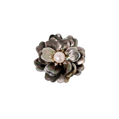 Elegant camellia brooch featuring black mother-of-pearl petals, a central white pearl, and shimmering zirconia accents