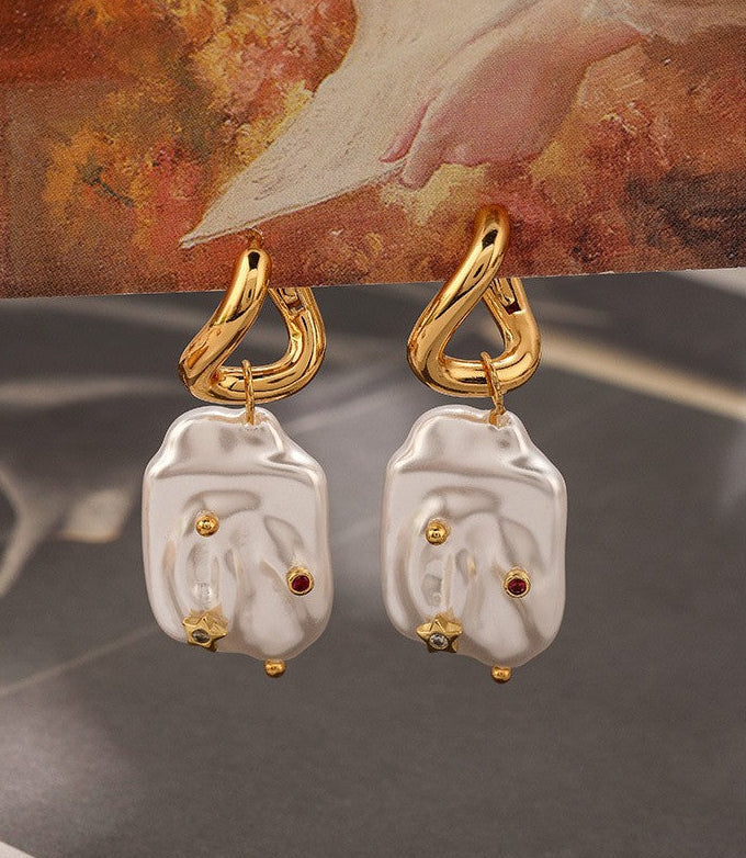 Natural Stainless steel jewelry baroque pearl huggie drop earrings inlaid with gold starburst cz crystal and ruby red stone accents.