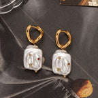 Natural Stainless steel jewelry baroque pearl huggie drop earrings inlaid with gold starburst cz crystal and ruby red stone accents.