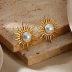 Paired vintage-style gold sunburst stud earrings featuring a central lustrous white pearl