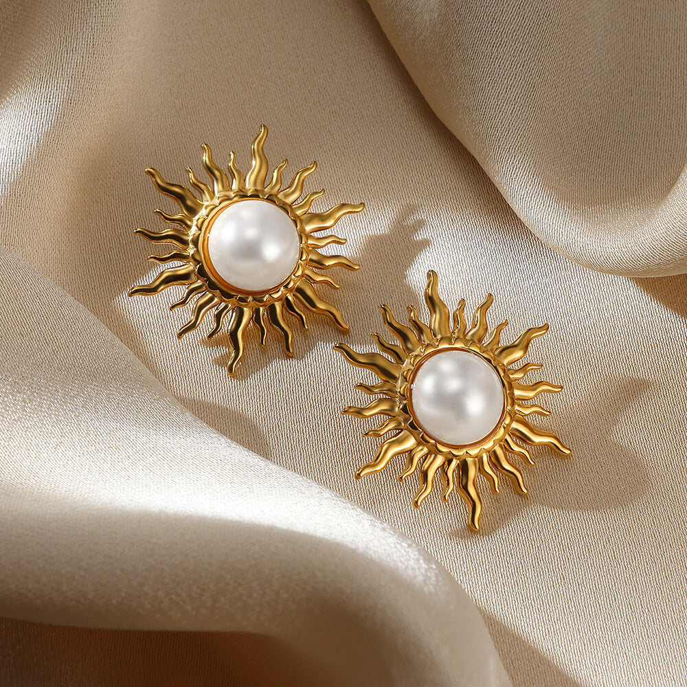 Paired vintage-style gold sunburst stud earrings featuring a central lustrous white pearl