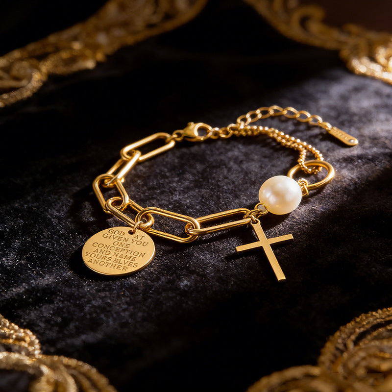 Cross charm pearl bead and engraved quote disc paperclip chain stainless steel jewelry bracelet in waterproof 18k gold plated finish.