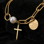 Cross charm pearl bead and engraved quote disc paperclip chain stainless steel jewelry bracelet in waterproof 18k gold plated finish.