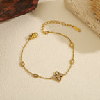 Cubic zirconia cz four petal flower pendant and oval bezel stations cable chain stainless steel jewelry bracelet in waterproof 18k gold plated finish.