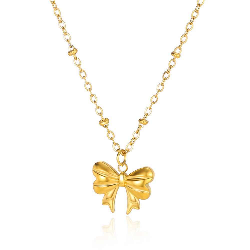 Minimalist gold bow pendant necklace featuring a polished three-dimensional bow on a dainty beaded chain for everyday elegance