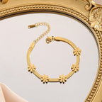 Daisy flower charm stations flat snake link chain stainless steel jewelry bracelet in waterproof 18k gold plated finish.