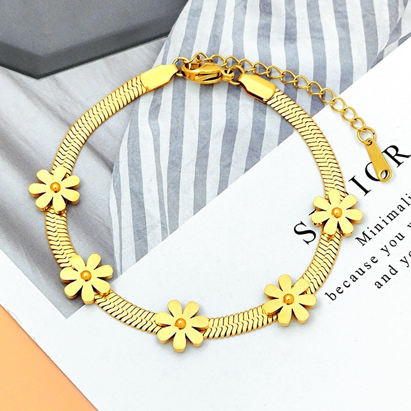 Daisy flower charm stations flat snake link chain stainless steel jewelry bracelet in waterproof 18k gold plated finish.