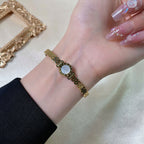 Round disc shell inlay and watch-band link mesh style stainless steel jewelry bangle in waterproof 18k gold plated finish.
