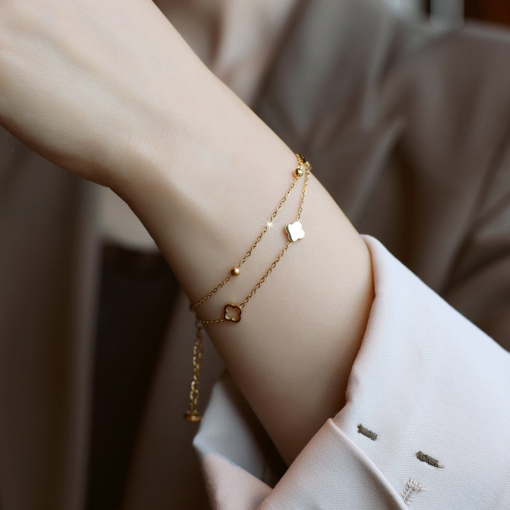 Double strand chain shell clover station and bead accent stainless steel jewelry bracelet in waterproof 18k gold plated finish.