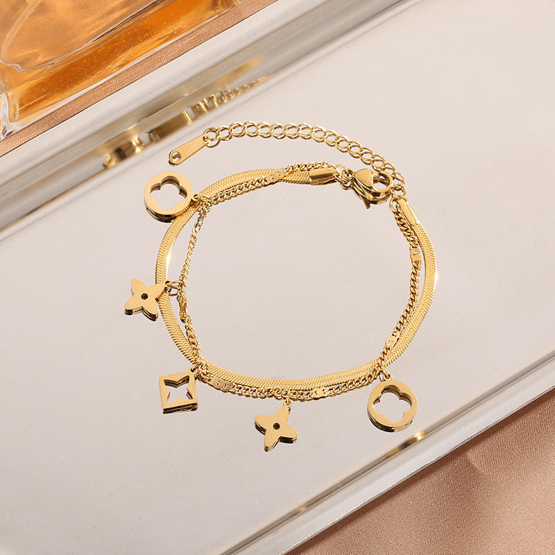 Double layer flat snake chain and cable link with clover motifs and geometric charms stainless steel jewelry bracelet in waterproof 18k gold plated finish.