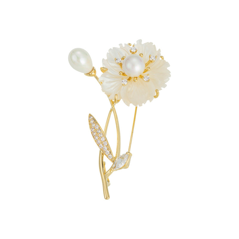 Elegant floral bouquet brooch featuring white cubic zirconia petals and a central pearl in a gold setting