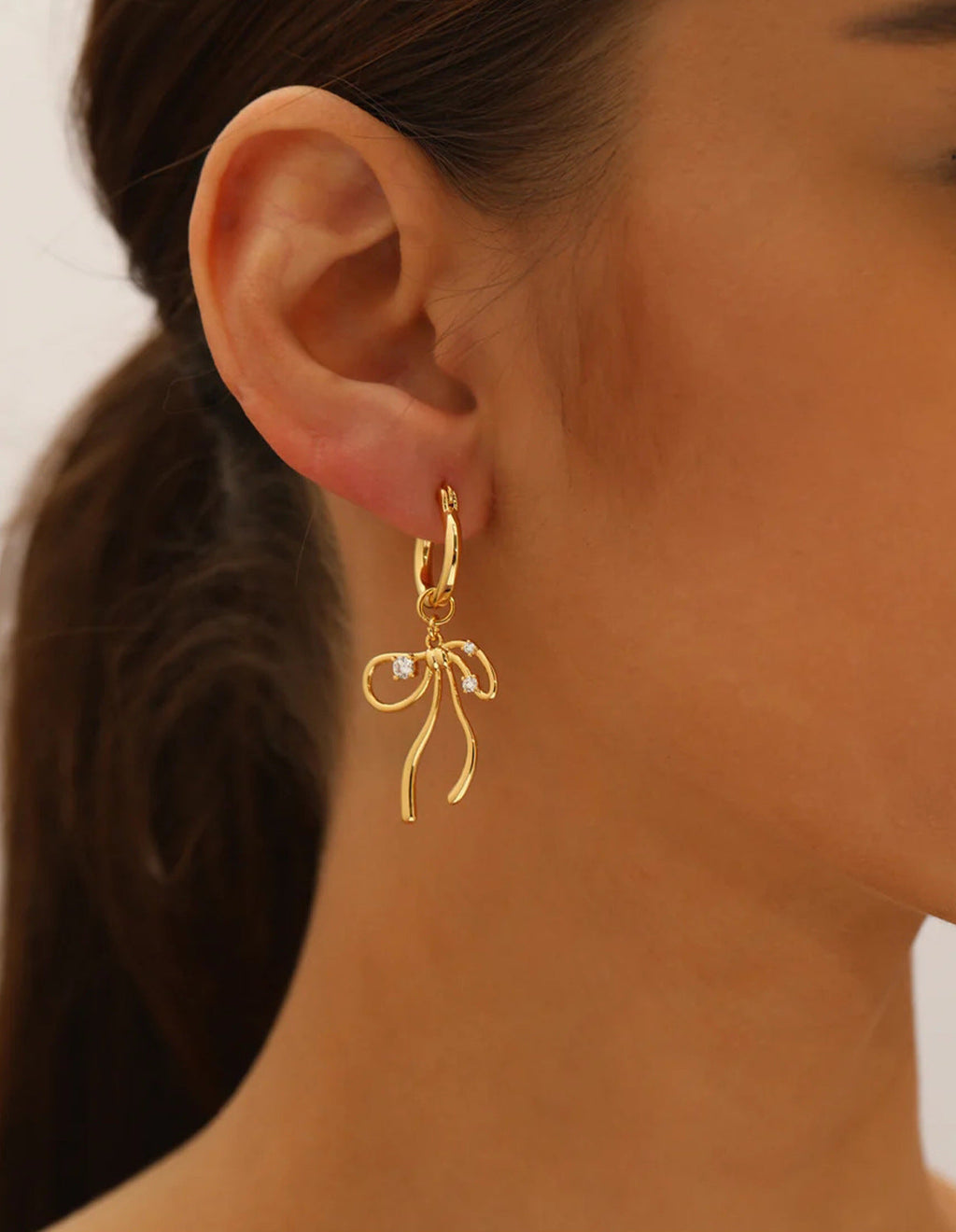 Elegant fluid ribbon bow charm huggie hoop earrings with cubic zirconia in 18k gold plated jewelry