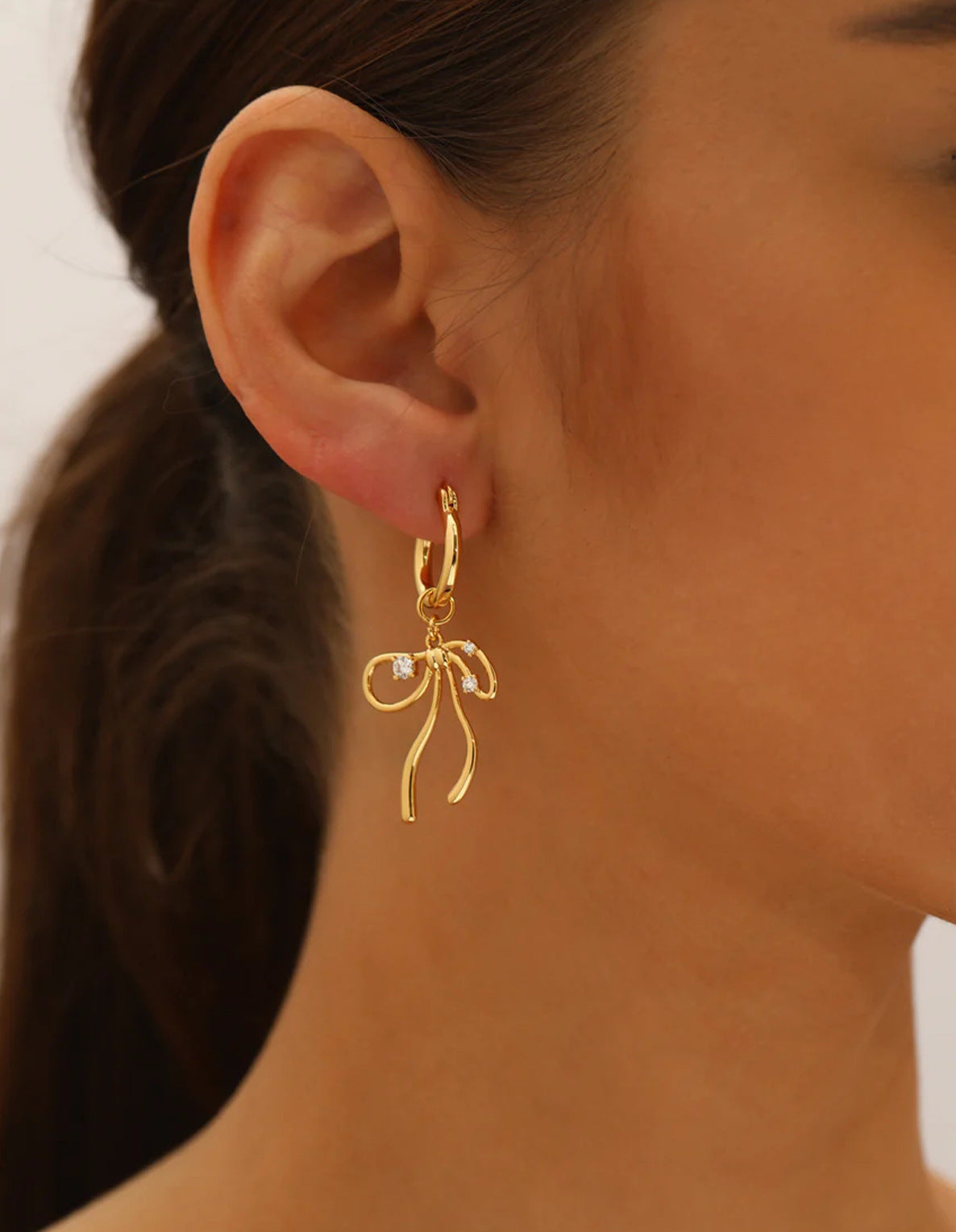 Elegant fluid ribbon bow charm huggie hoop earrings with cubic zirconia in 18k gold plated jewelry