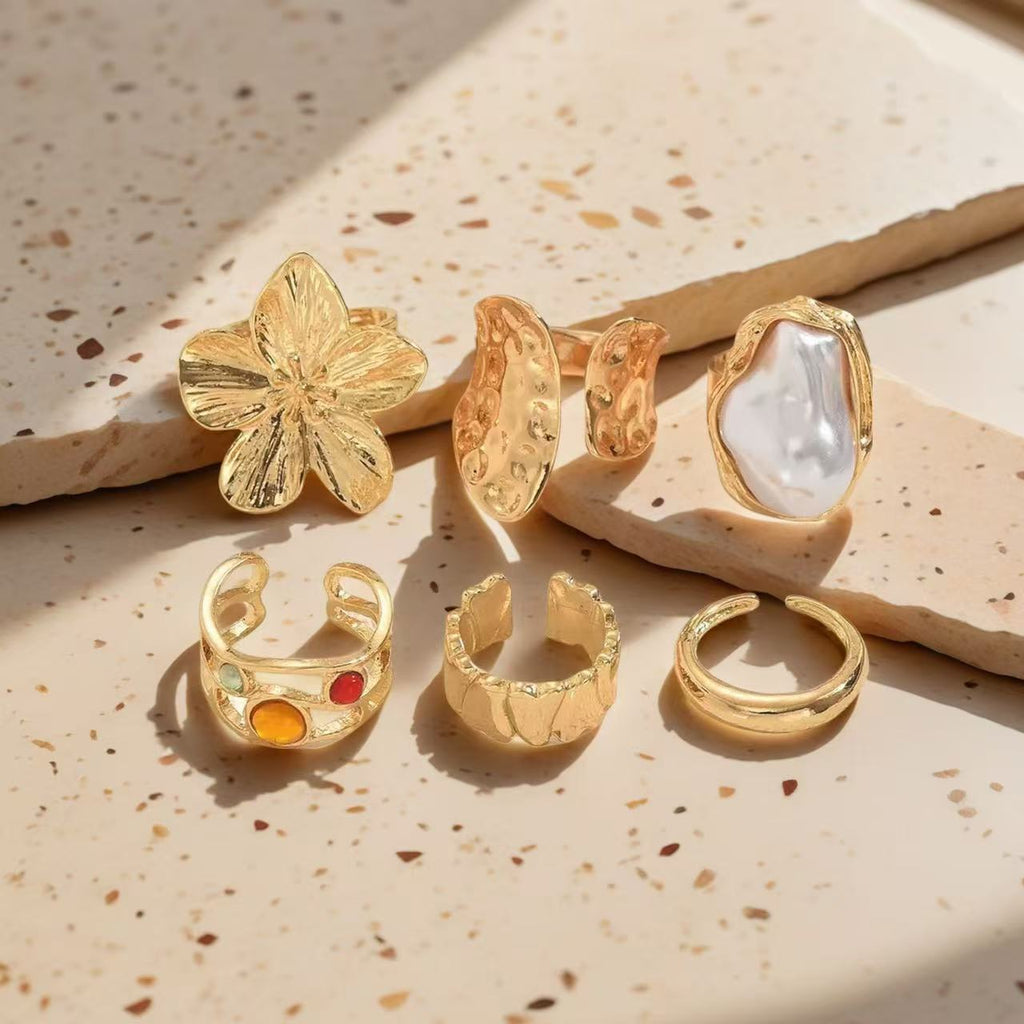 Textured open cuff flower motif, baroque pearl accent, and hammered gold bands 6 piece adjustable stackable ring set stainless steel jewelry in waterproof 18k gold plated finish.