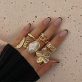 Textured open cuff flower motif, baroque pearl accent, and hammered gold bands 6 piece adjustable stackable ring set stainless steel jewelry in waterproof 18k gold plated finish.