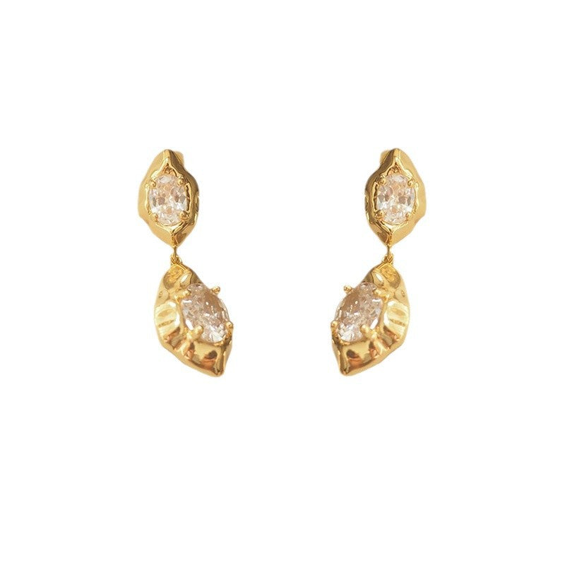 A pair of geometric drop earrings with a hammered gold texture and brilliant oval zircon accents