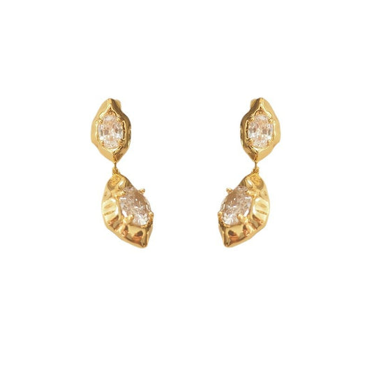 A pair of geometric drop earrings with a hammered gold texture and brilliant oval zircon accents