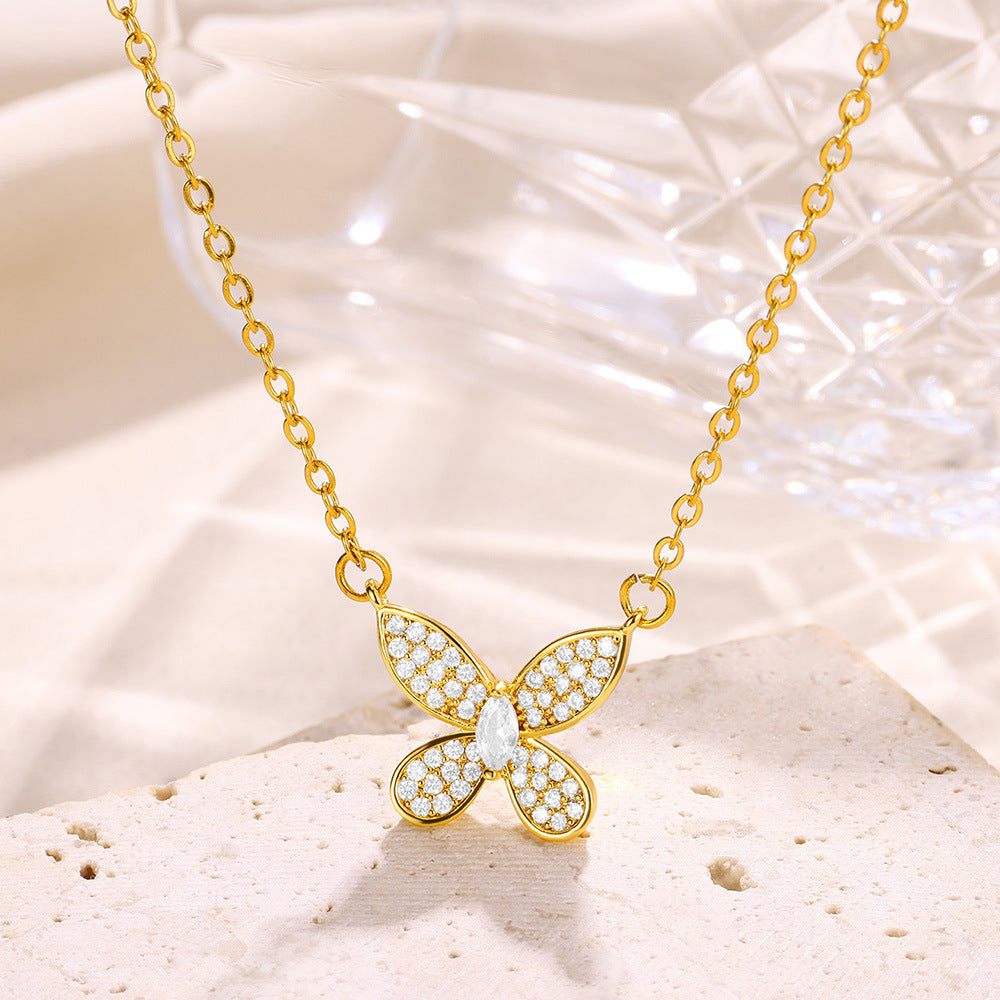 Elegant gold bow pendant necklace featuring a dainty butterfly ribbon design adorned with sparkling zircon accents