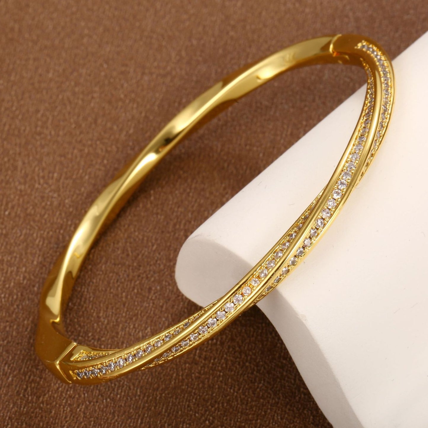 Modern gold bypass wrap bangle featuring dual round halo charms with sparkling white cubic zirconia