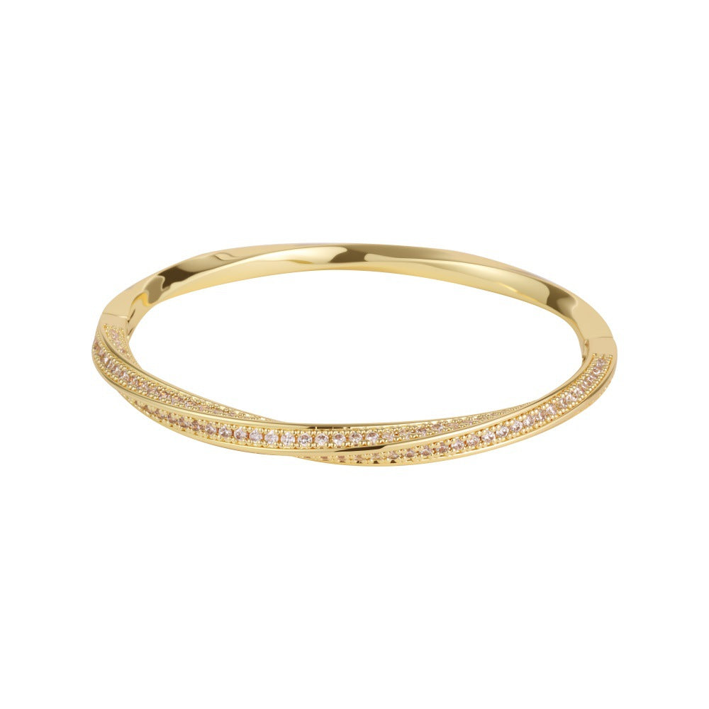 Modern gold bypass wrap bangle featuring dual round halo charms with sparkling white cubic zirconia