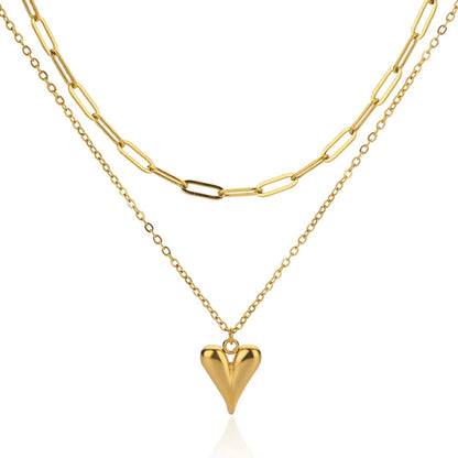 Elegant gold double-layer necklace featuring a minimalist heart pendant on a chic layered delicate chain