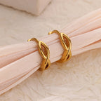Paired minimalist gold stud earrings featuring a polished infinity symbol design for an elegant, timeless look