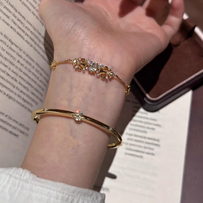 Elegant gold bracelet featuring a delicate iris flower charm paved with sparkling white cubic zirconia