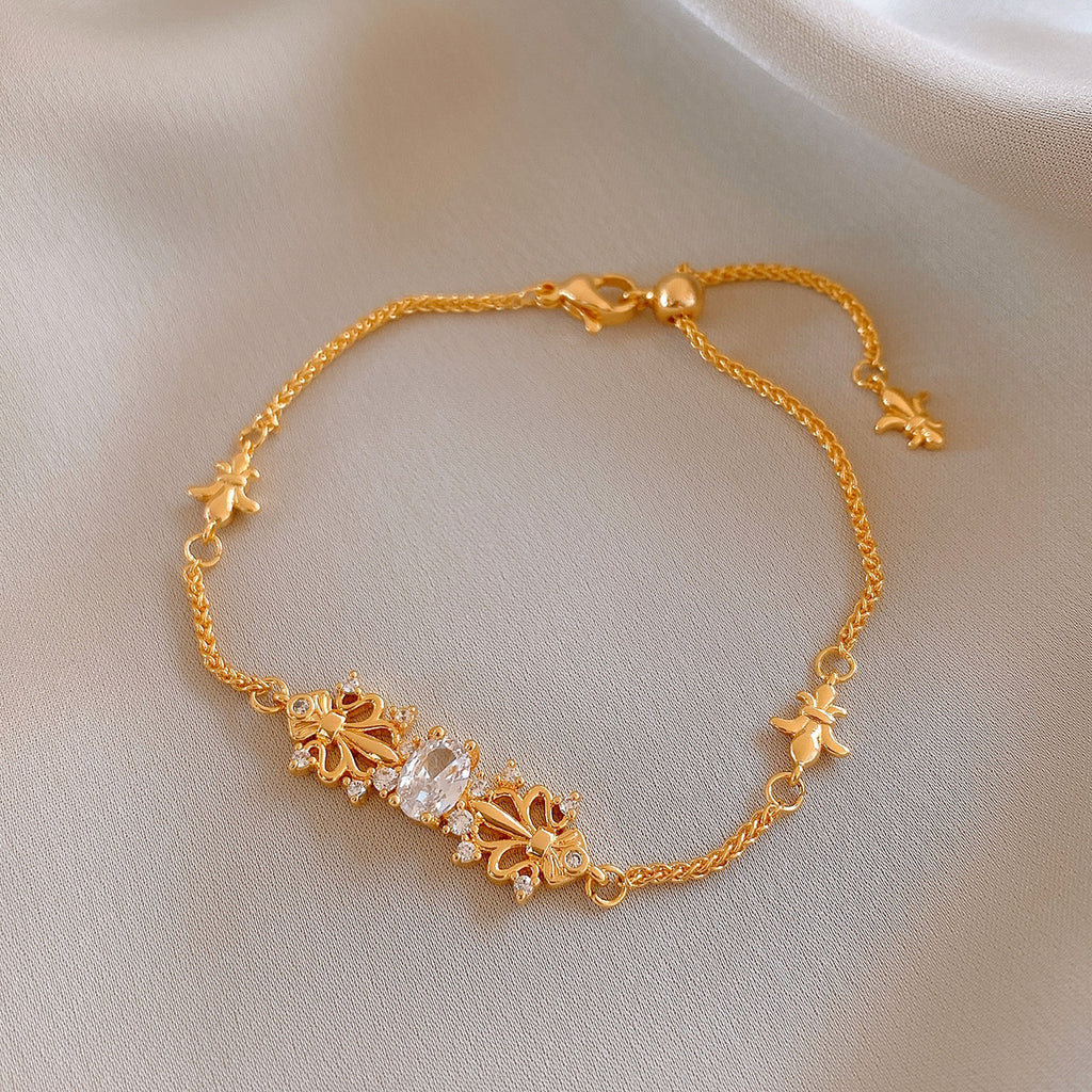 Elegant gold bracelet featuring a delicate iris flower charm paved with sparkling white cubic zirconia