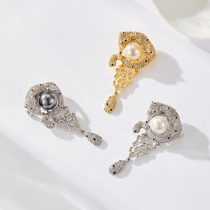 Luxurious gold leopard brooch with sparkling white zirconia and a large central pearl in a wild animal design