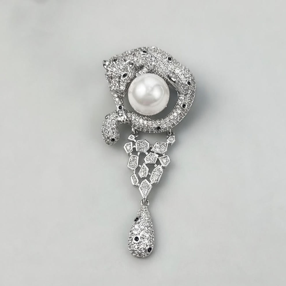 Luxurious gold leopard brooch with sparkling white zirconia and a large central pearl in a wild animal design