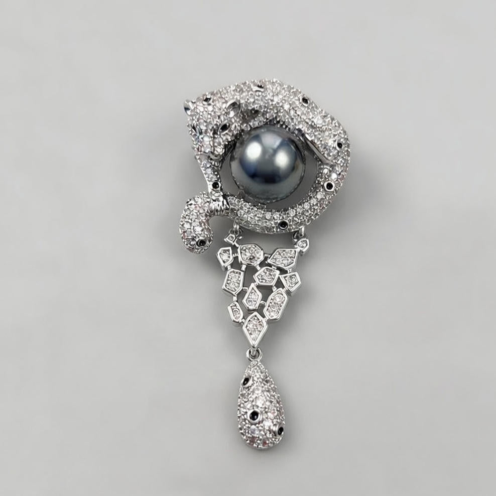 Luxurious gold leopard brooch with sparkling white zirconia and a large central pearl in a wild animal design