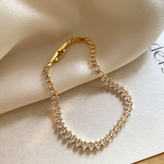 Elegant gold tennis bracelet featuring marquise-cut white cubic zirconia stones in a leaf-style continuous link