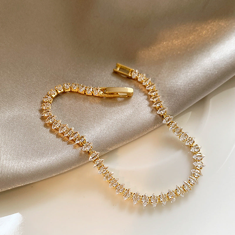 Elegant gold tennis bracelet featuring marquise-cut white cubic zirconia stones in a leaf-style continuous link