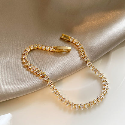 Elegant gold tennis bracelet featuring marquise-cut white cubic zirconia stones in a leaf-style continuous link
